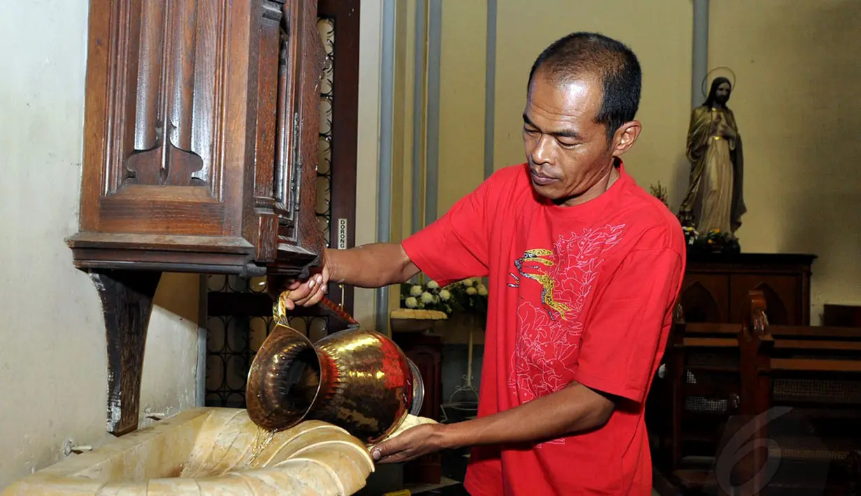 Petugas gereja Katedral menyiapkan air suci jelang Misa Malam Natal 2014 pada Rabu pagi (24/12/2014). (Liputan6.com/Miftahul Hayat)