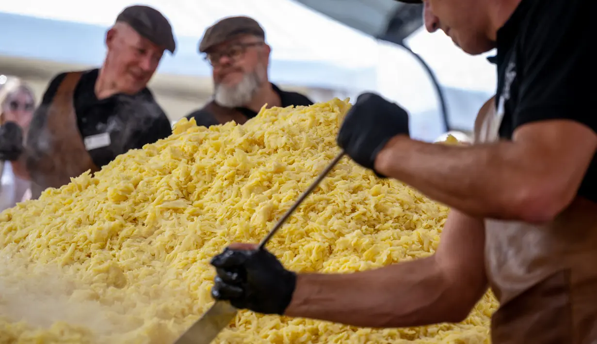 Koki memasak rosti dalam upaya memecahkan rekor dunia saat acara yang menandai peringatan 125 tahun Serikat Petani Swiss (SBV) di Bern, Swiss pada 19 September 2022. Petani Swiss berhasil memecahkan rekor roesti terbesar di dunia yang dibuat di atas wajan berbentuk salib dengan ukuran 13.7 meter persegi. (Fabrice COFFRINI / AFP)