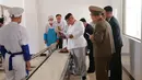 Pemimpin Korea Utara Kim Jong-un (tengah) memeriksa salah satu produk ransum militer saat mengunjungi Pabrik No. 525 di Korea Utara, Rabu (25/7). (STRINGER/AFP/KCNA VIA KNS)
