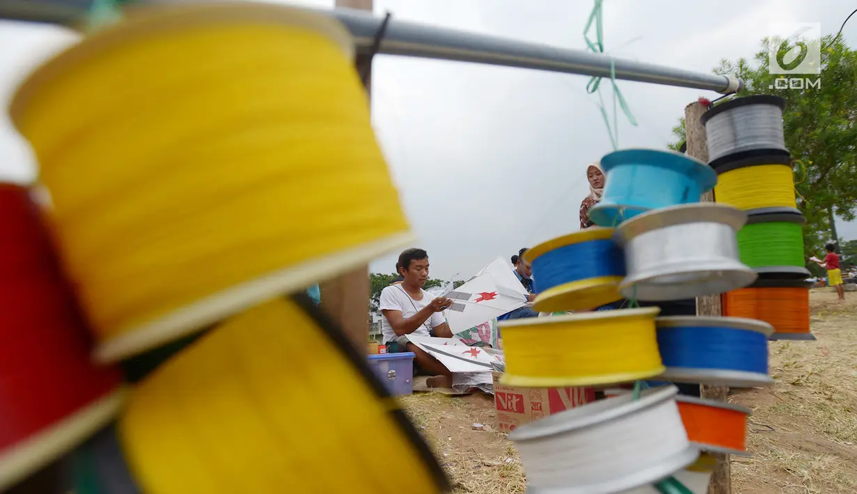 Pedagang menata layang-layang yang dia jual di tepi Kanal Banjir Timur (KBT), Jakarta, Jumat (5/7/2019). Pedagang menjual layang-layang seharga Rp 1.000 per buah. (merdeka.com/Imam Buhori)