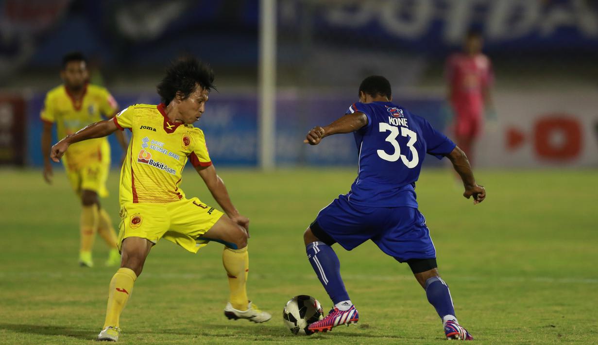 Pemain Sriwijaya FC Asri Akbar (kiri) berebut bola dengan pemain Arema Cronus Lancine Kone  pada laga semifinal Piala Presiden di Stadion Manahan, Solo, Minggu (11/10/2015). Sriwijaya menang 2-1. (Bola.com/Nicklas Hanoatubun).