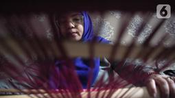 Warga mengikuti pelatihan pembuatan kain tenun motif Betawi di Rusunawa Jatinegara, Jakarta, Rabu (13/11/2019). Pemerintah akan memprioritaskan penyaluran KUR kelompok, seiring dengan diturunkannya suku bunga KUR per 1 Januari 2020 menjadi 6 persen, dari  7 persen. (Liputan6.com/Angga Yuniar)