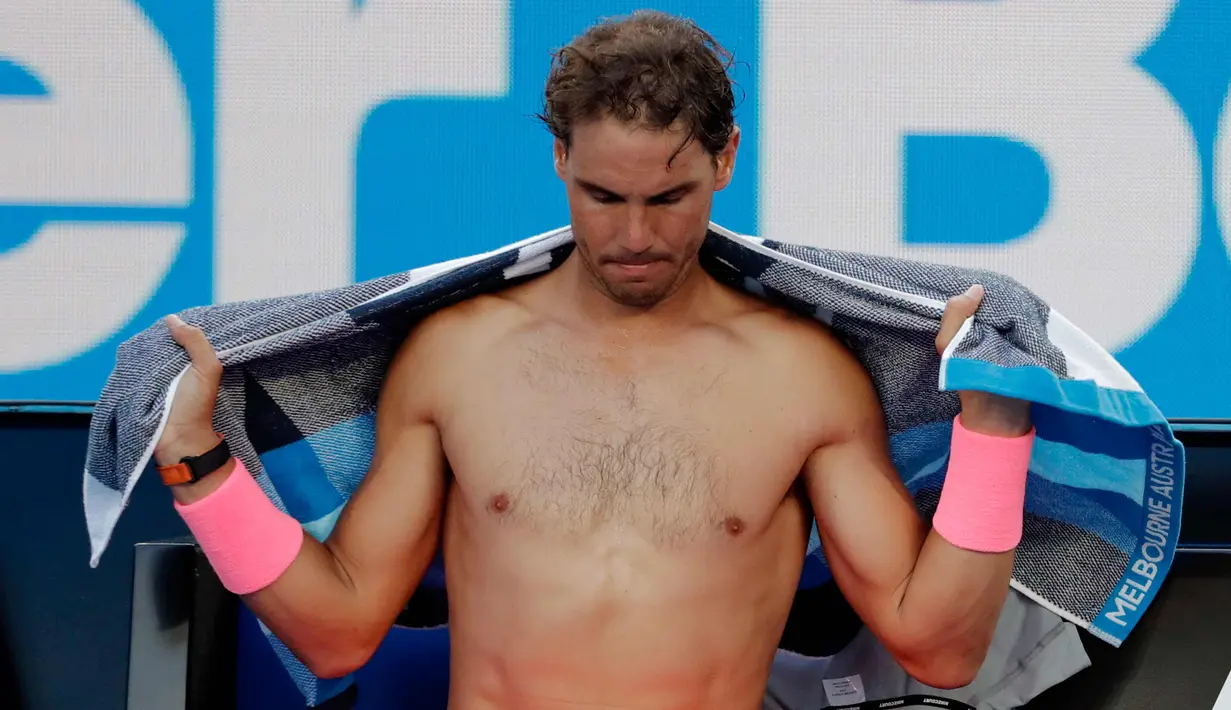 Petenis Spanyol Rafael Nadal mengeringkan diri dengan handuk saat istirahat pada pertandingan melawan Victor Estrella Burgos dari Republik Dominika di kejuaraan tenis Australia Terbuka di Melbourne, Australia, (15/1). (AP Photo / Vincent Thian)