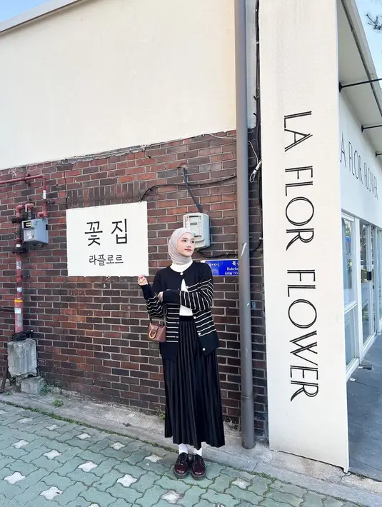 Striped cardigan berwarna hitam sempurna dipadukan turtleneck berwarna putih dan rok plisket untuk OOTD kasual. [Instagram/raniaskdr_]