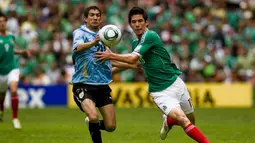 Striker Meksiko, Marco Bueno (kanan) berebut bola dengan bek Uruguay, Alejandro Furia pada laga final Piala Dunia U-17 2011 di Azteca Stadium, Meksiko (10/7/2011). Pada Piala Dunia U-17 2011 yang digelar di Meksiko pada 18 Juni hingga 10 Juli 2011, tuan rumah Meksiko sukses menjadi juara setelah mengalahkan Uruguay dengan skor 2-0 di laga final. Dua gol kemenangan Meksiko dicetak Antonio Briseno dan Giovani Casillas. (AFP/Alfredo Estrella)