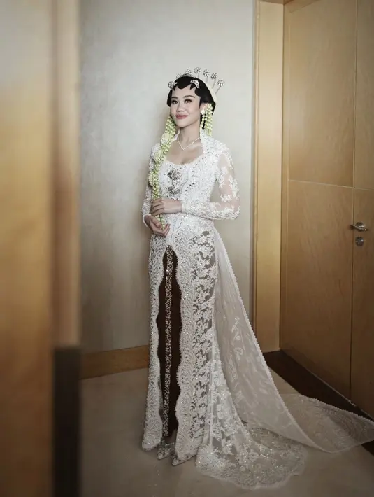 Kebaya pengantin adat Jawa Aaliyah Massaid merupakan rancangan Rika Wirtjes, memiliki desain dramatis yang panjang menjuntai hingga ke lantai. [Foto: Instagram/rikawirtjes]