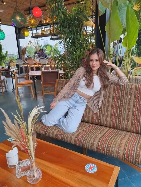 Tampilan kekinian Wulan Guritno. Ia memadukan sleeveless crop top dengan high waist jeans dan cardigan. (Instagram/wulanguritno).