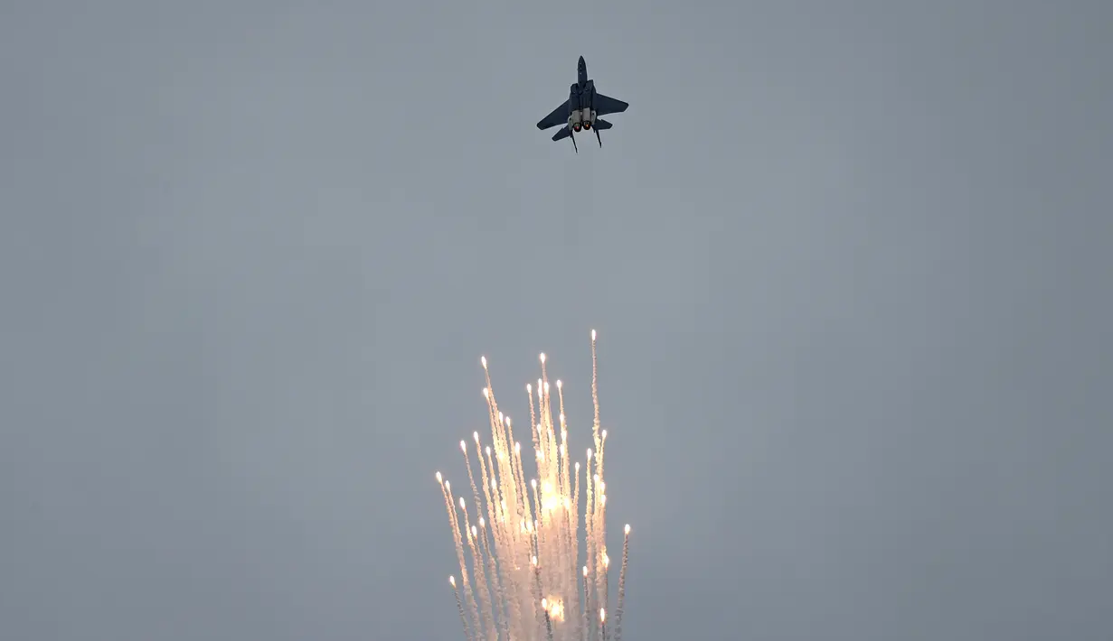 Jet tempur F-15SG dari Angkatan Udara Republik Singapura melakukan manuver di udara sambil mengeluarkan flair jelang Singapore Airshow 2018, Jumat (2/2). (AP Photo/Wong Maye-E)