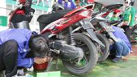 Montir menservis dan ganti oli motor milik buruh secara gratis di Lapangan Ahmad Yani, Tangerang, banten (1/5). Lebih 500 sepeda motor medapatkan servis dan ganti oli secara gratis oleh Serikat Pekerja Seleruh Indonesia. (Merdeka.com/Arie Basuki)