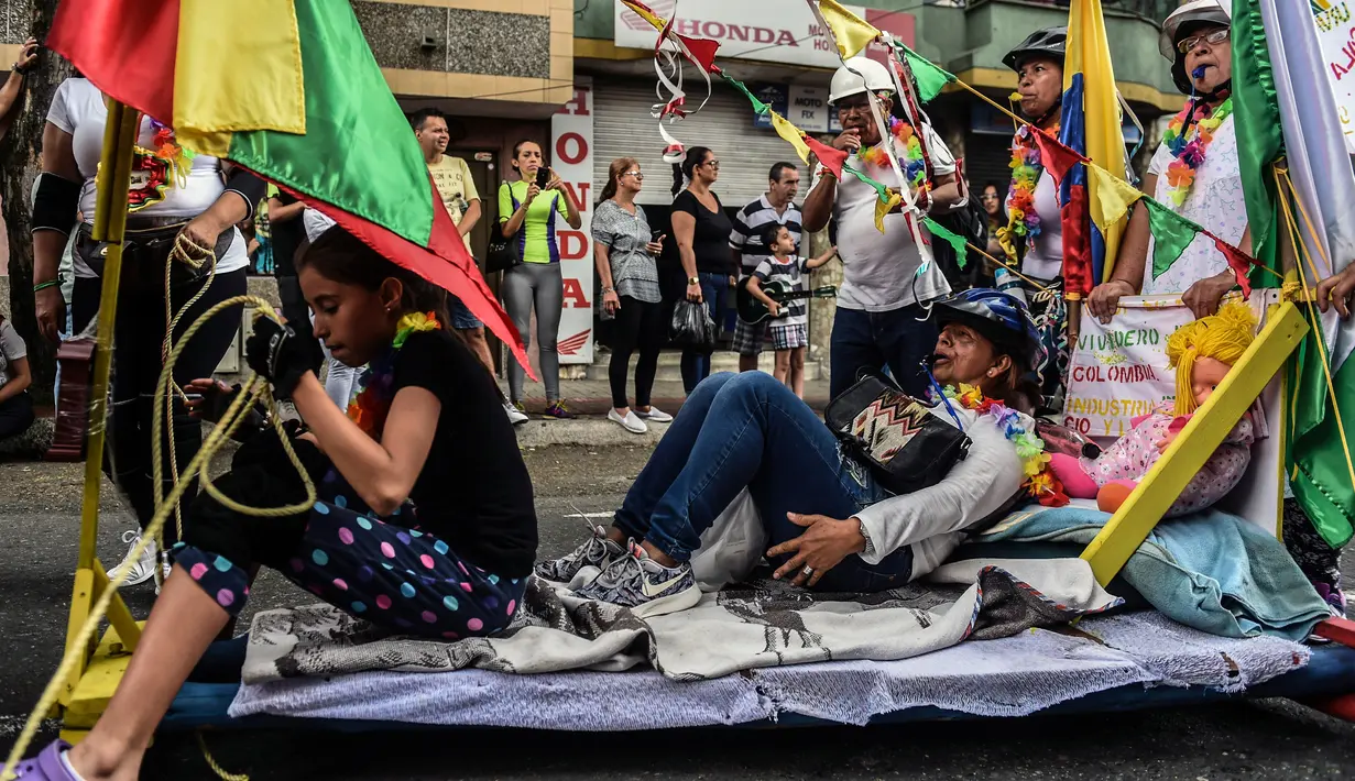 Warga Kolombia turun ke jalanan dan bermalas-malasan di atas tempat tidur pada pawai merayakan Hari Kemalasan Sedunia di Itagui, dekat Medellin, Minggu (19/8). Perayaan ini membantu mengingatkan mereka akan perlunya memanjakan diri (AFP/JOAQUIN SARMIENTO)