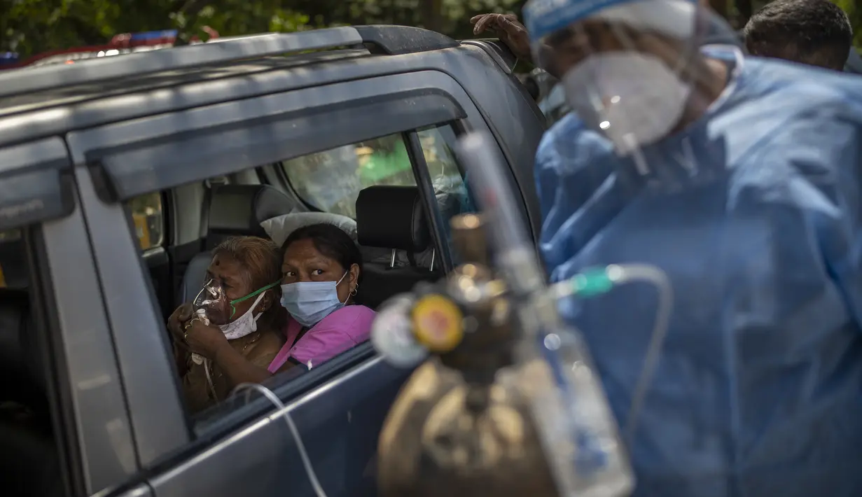 Seorang pasien menerima oksigen di dalam mobil yang disediakan oleh Gurdwara, tempat ibadah Sikh, di New Delhi, 24 April 2021. Banyak kota di India kewalahan oleh pasien yang mengakibatkan kekurangan tempat tidur rumah sakit dan oksigen yang menyebabkan ribuan kematian. (AP Photo/Rajesh Kumar Singh)