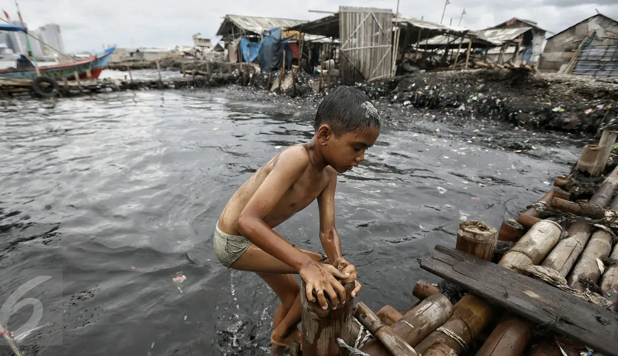 Seorang anak seusai bermain air di kawasan pantai penuh sampah yang terbawa arus di Muara Angke, Jakarta, Rabu (10/2). Genangan sampah yang terbawa arus oleh angin musim barat ini tak menyurutkan anak-anak untuk bermain air. (Liputan6.com/Faizal Fanani)