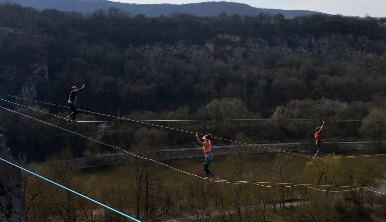Sejumlah peserta berusaha menjaga keseimbangannya saat berjalan diatas tali dalam festival slackline , di sebuah tambang dekat Beroun, Republik Ceko (25/3). (AFP/Michal Cizek)