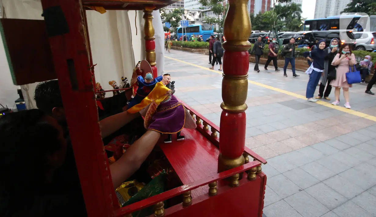 Dalang memainkan wayang potehi di Taman Budaya Dukuh Atas, Jakarta, Jumat (7/2/2020). Pagelaran pertunjukan wayang Tionghoa ini merupakan rangkaian kebudayan imlek yang di gelar oleh Pemprov DKI Jakarta. (Liputan6.com/Angga Yuniar)