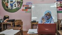 Pendidik membimbing murid saat kelas sentra seni secara virtual di PAUD Cempaka, Jakarta, Senin (23/11/2020). Selama Covid-19, kegiatan belajar virtual melalui kelas sentra atau praktik digelar guna meningkatkan kreativitas dan daya tangkap meski belajar dari rumah. (merdeka.com/Iqbal S Nugroho)