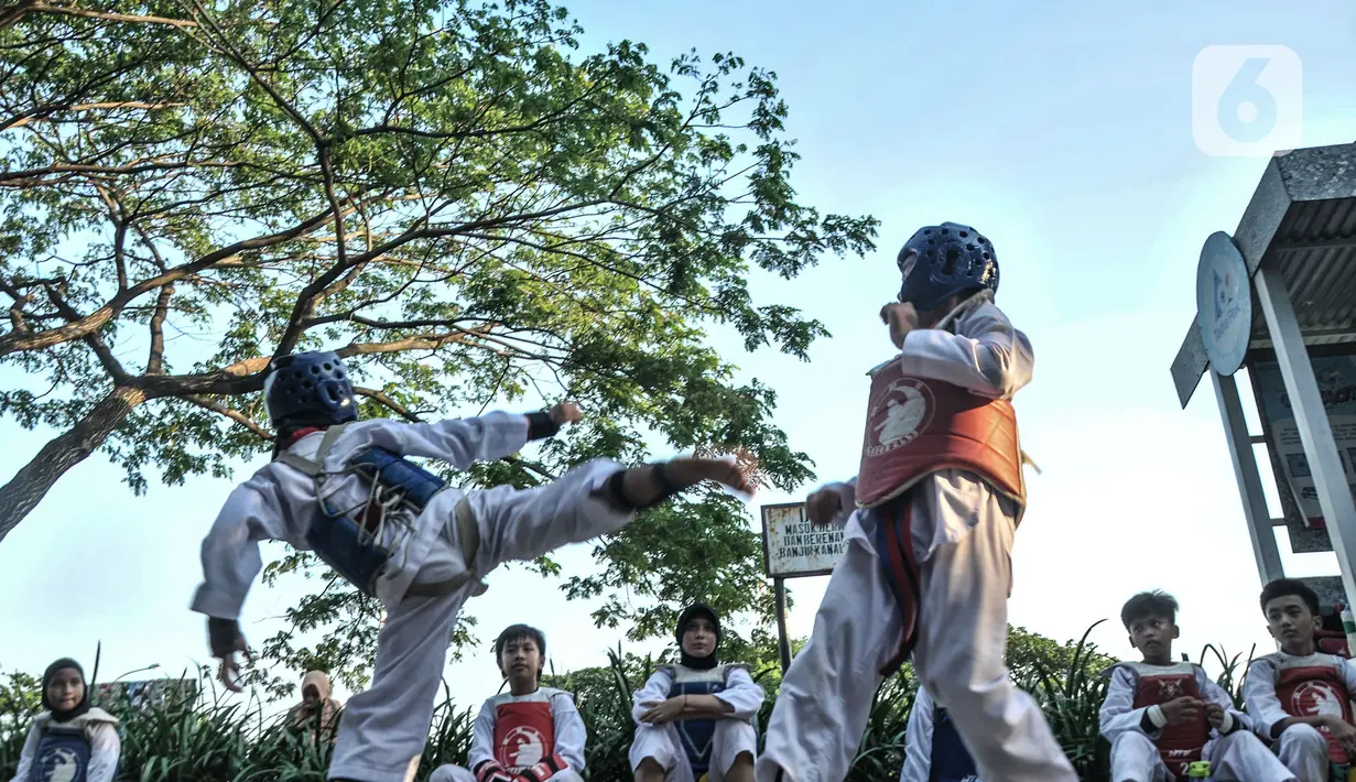 Murid Taekwondo Indonesia Manroe Club mengikuti latihan rutin di kawasan Kanal Banjir Timur (KBT), Jakarta Timur, Senin (16/8/2021). Protokol kesehatan dilakukan terhadap murid maupun orangtua yang mengantarkan anak mereka. (merdeka.com/Iqbal S. Nugroho)