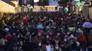 Orang-orang yang memakai masker untuk melindungi diri dari penyebaran virus corona berjalan di sepanjang jalan komersial di pusat kota Madrid, Spanyol (8/12/2021). PM Spanyol mendesak warga untuk "tetap berhati-hati" tentang COVID-19 selama liburan perayaan Natal. (AP Photo/Manu Fernandez)