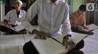 Pelajar penyandang tuna netra mengikuti Tadarus Al Quran braille di Yayasan Tunanetra Raudlatul Makmufin Serpong, Tangerang Selatan, Banten, Rabu (28/4/2021). Selama bulan suci Ramadhan, Yayasan Tunanetra Raudlatul Makmufin mewajibkan pelajar untuk mengkhatamkan Alquran. (Liputan6.com/Angga Yuniar)