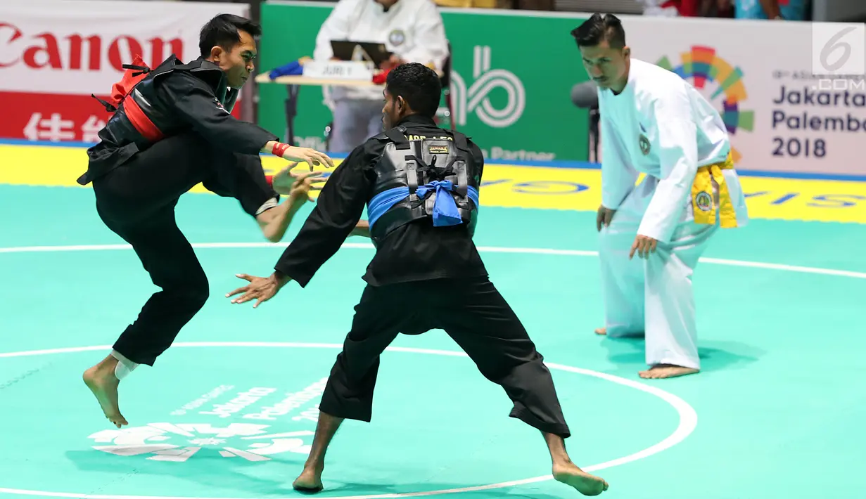 Pesilat Indonesia, Komang Harik Adiputra melepas tendangan ke arah pesilat Timor Leste, David No-Ano Ximenes pada kelas 65-70 kg Putra Asian Games 2018 di Padepokan Pencak Silat TMII, Jakarta, Kamis (23/8). Komang unggul 5-0. (Liputan6.com/Fery Pradolo)