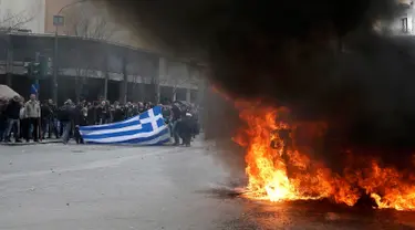 Sejumlah petani Yunani berunjuk rasa membakar sampah selama protes terhadap perubahan peraturan pensiun yang direncanakan di luar Kementerian Pertanian, Athena, Yunani, Jumat (12/2). (REUTERS/Alkis Konstantinidis)