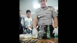 Selain itu, polisi juga mengamankan 22 botol minuman beralkohol, 3 buah bom molotov, 25 botol minuman bir besar, 5 botol minuman bir kecil, 4 buah pisau, kampak, gunting, klemang, 1 kantong plastik sumbu, dan 1 krat botol. (Liputan6.com/Faizal Fanani)