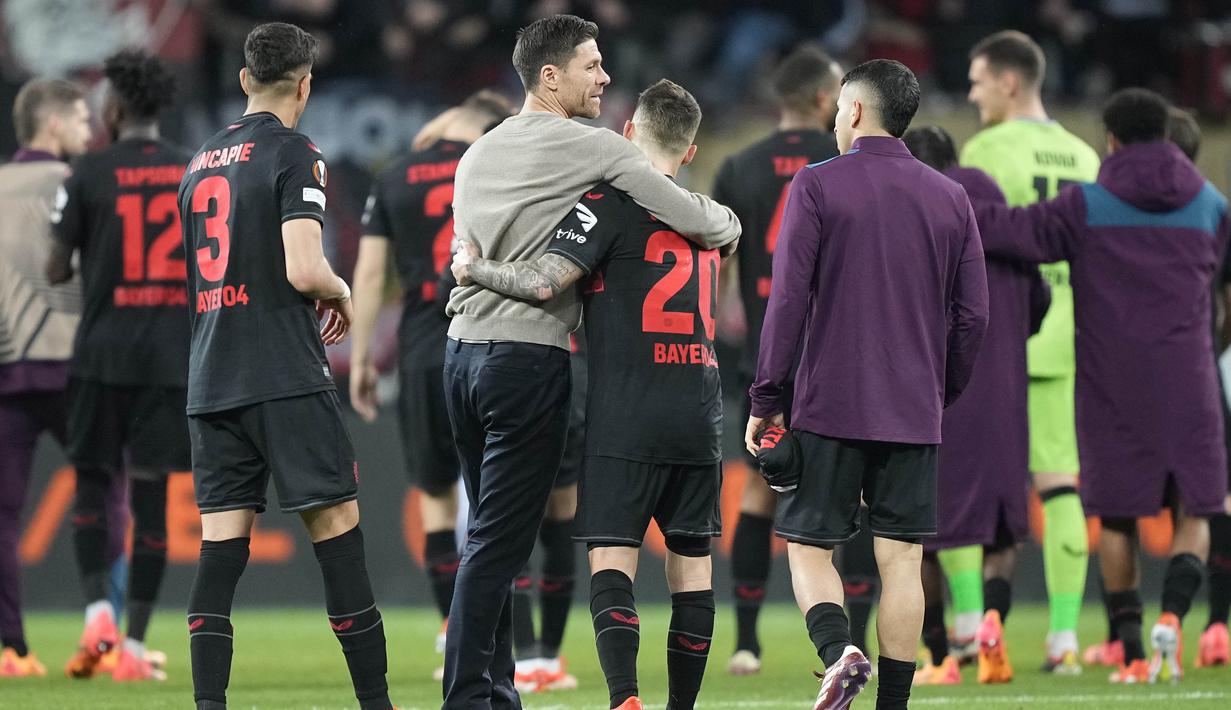 Pelatih Bayer Leverkusen, Xabi Alonso, bersama Alex Grimaldo  merayakan kemenangan atas West Ham United pada laga Perempat final Liga Europa di Stadion BayArena, Jumat (12/4/2024). Pasukan Xabi Alonso baru bisa mencetak dua gol pada ujung pertandingan berkat pemain pengganti mereka yaitu Jonas Hoffmann dan Victor Boniface. (AP Photo/Martin Meissner)