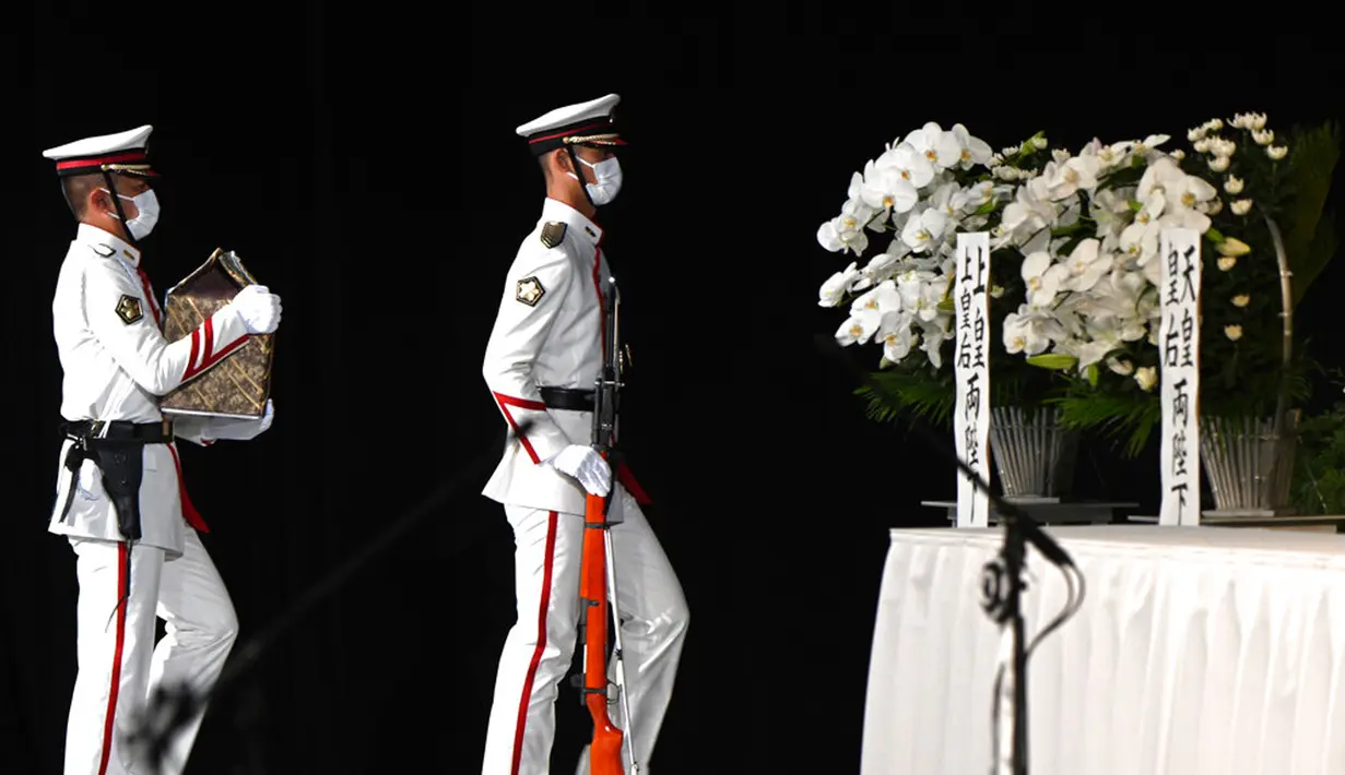Anggota pengawal kehormatan membawa abu mantan Perdana Menteri Jepang Shinzo Abe ke altar saat pemakaman kenegaraan dimulai di Nippon Budokan, Tokyo, Jepang, 27 September 2022. Pemakaman kenegaraan untuk Shinzo Abe itu sejatinya menuai pro-kontra. (Philip Fong/Pool Photo via AP)