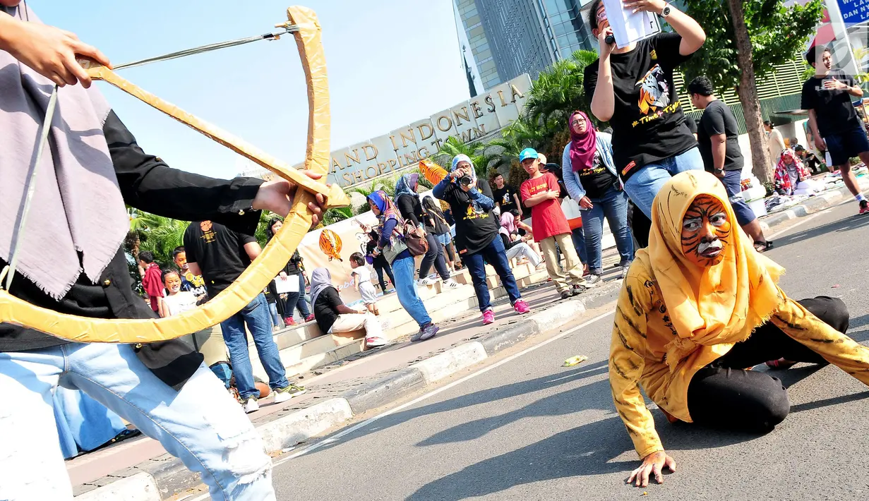 Sejumlah massa yang tergabung dalam forum harimaukita menggelar aksi teatrikal saat mengkampanyekan Global Tiger Day di Bundaran Hotel Indonesia (HI), Jakarta, Minggu (30/7). (Liputan6.com/Helmi Afandi)
