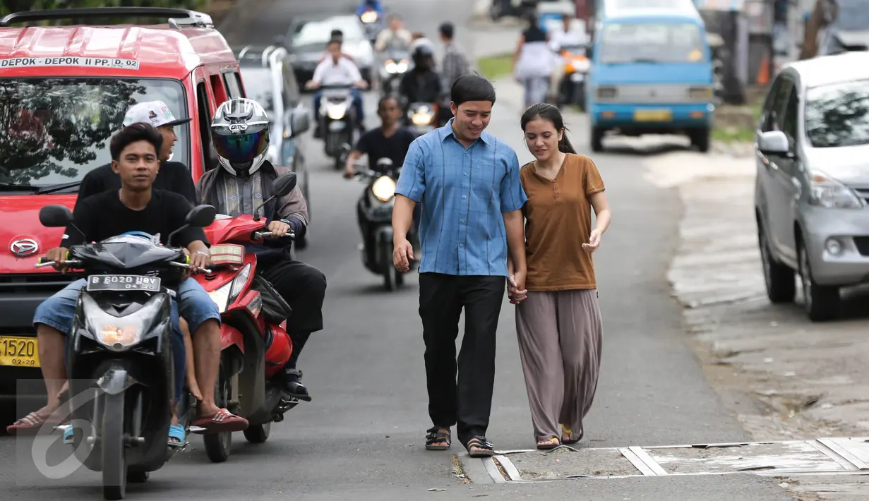 Vokalis band Repvblik, Ruri berjalan dengan seorang wanita saat syuting pembuatan video klip 'Sayang Sampai Mati' di kawasan Depok, Jawa Barat, Kamis (19/1). (Liputan6.com/Herman Zakharia)