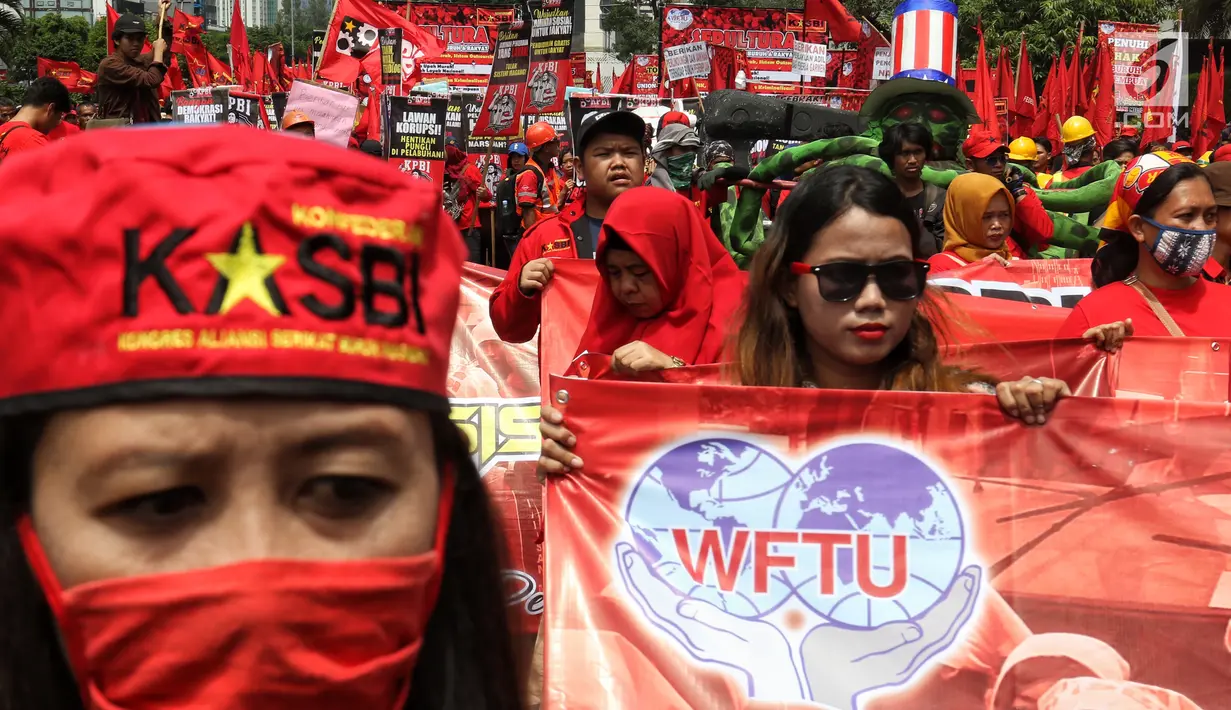 Peserta aksi dari sejumlah elemen buruh mengikuti aksi memperingati Hari Buruh Sedunia di kawasan Bundaran HI, Jakarta, Rabu (1/5/2019). Massa aksi dalam peringatan Hari Buruh 2019 tidak dapat mendekati Istana Merdeka lantaran tertahan di kawasan tersebut. (Liputan6.com/Johan Tallo)