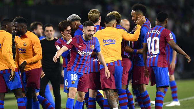 <p>Pemain Barcelona Jordi Alba (tengah) merayakan setelah mencetak gol ke gawang Real Betis pada pertandingan sepak bola La Liga Spanyol di Stadion Benito Villamarin, Seville, Spanyol, 7 Mei 2022. Barcelona menang 2-1. (AP Photo/Jose Breton)</p>