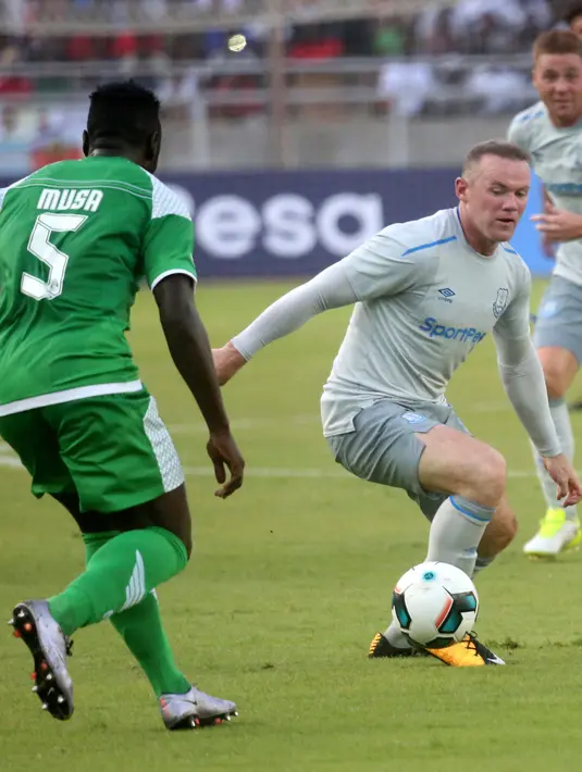 Striker Everton, Wayne Rooney (kanan) mencoba lolos dari kawalan pemain Gor Mahia pada pertandingan persahabatan di Tanzania, Kamis (13/7).  Rooney kembali tampil dalam seragam Everton setelah resmi meninggalkan Manchester United. (AP Photo/Khalfan Said)