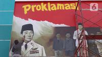 Pekerja tengah membuat mural detik detik proklamasi kemerdekaan Republik Indonesia di Pondok Aren, Tangerang Selatan, Rabu (22/7/2020). Pembuatan mural tersebut untuk menyambut HUT Kemerdekaan RI ke-75 pada bulan Agustus mendatang. (Liputan6.com/Angga Yuniar)