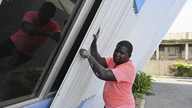 Seorang pria melindungi rumahnya menjelang kedatangan Badai Beryl di Jamaika, Selasa (2/7/2024). (AP/Collin Reid)