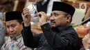 Menteri Agama Yaqut Cholil Qoumas membersihkan kaca mata saat membahas draft penetapan biaya haji 2023 dalam rapat panja bersama Komisi VIII DPR RI di kompleks Parlemen, Senayan, Jakarta, Rabu (15/2/2023). Pemerintah bersama legislator menyepakati biaya haji yang harus dibayarkan jemaah sebesar Rp 49.812.700. Angka itu disepakati dalam rapat Panja yang dgelar di Kompleks Parlemen, Jakarta, Rabu (15/2). (Liputan6.com/Faizal Fanani)