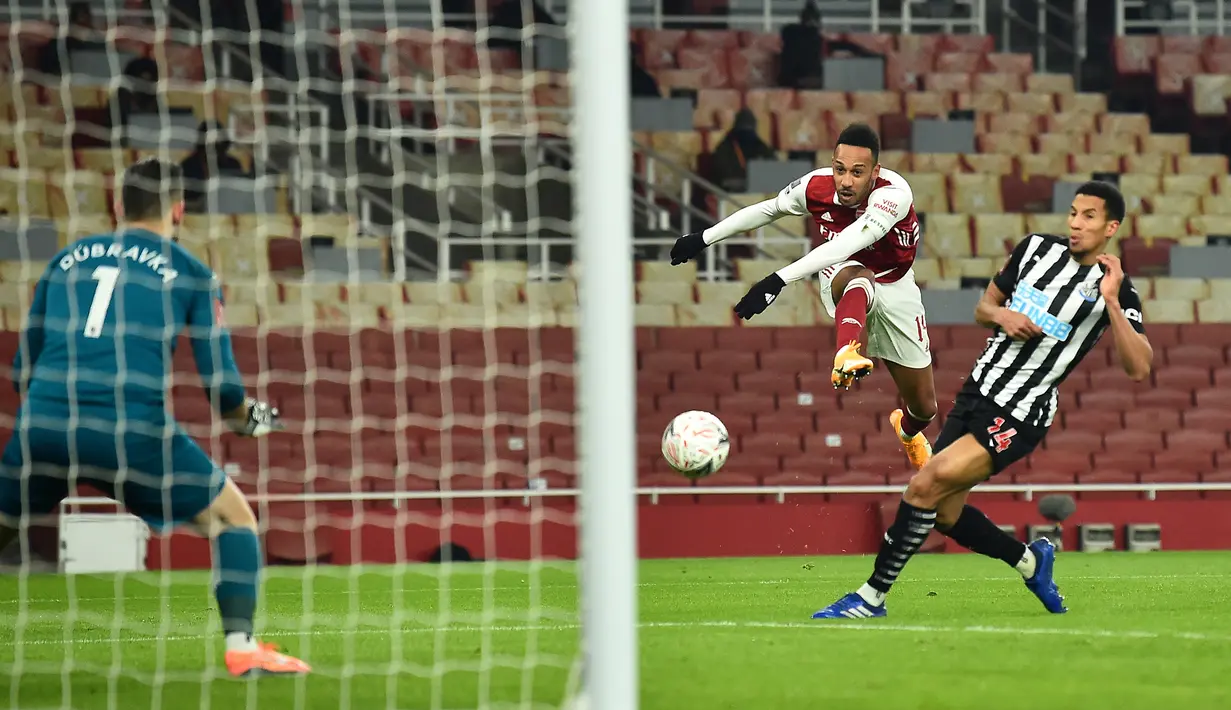 Striker Arsenal, Pierre-Emerick Aubameyang (tengah) melepaskan tendangan ke gawang Newcastle United dalam laga babak ke-3 Piala FA 2020/21 di Emirates Stadium, Sabtu (9/1/2021). Arsenal menang 2-0 atas Newcastle United melalui extra time. (AFP/Glyn Kirk/Pool)