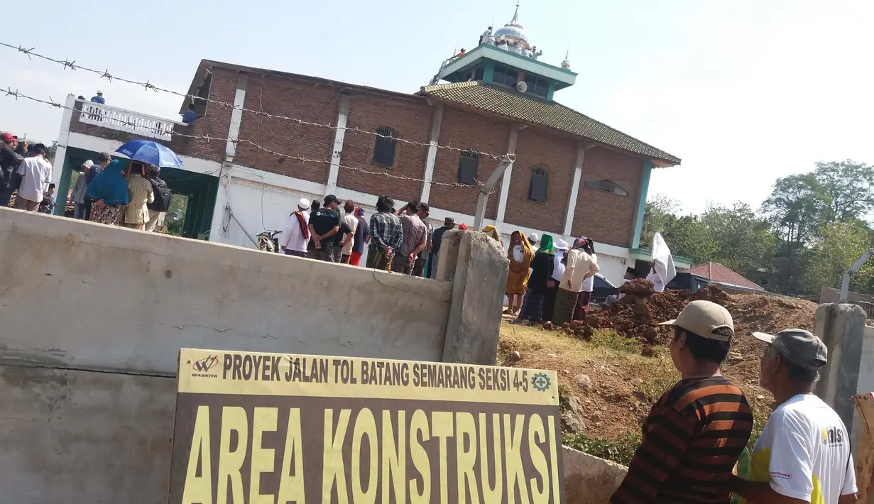 Suasana pembongkaran Masjid Baitul Mustaghfirin yang berada di tengah tol fungsional Batang-Semarang, Jumat (28/9). Warga saling bahu membahu menurunkan 4 kubah kecil dan 1 kubah besar di atas masjid. (Liputan6.com/Gholib)