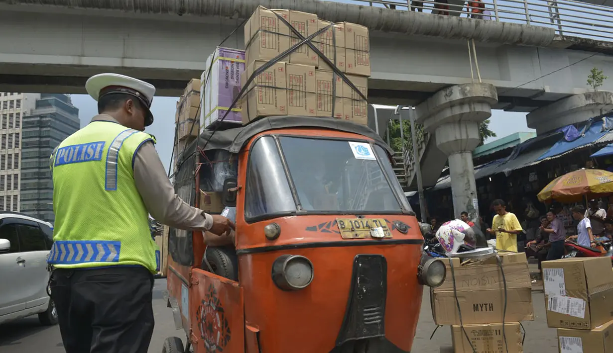 Polisi menilang pengemudi bajaj yang membawa muatan berlebihan ketika digelar Operasi Zebra 2014 di sekitar Pasar Senen, Jakarta, Rabu (26/11). (ANTARA FOTO/Saptono)