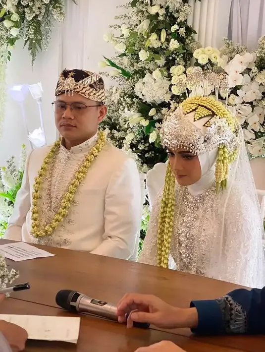 Nadya Mustika tampil cantik dengan busana pengantin warna putih. Adik ipar Larissa Chou ini begitu lancar mengucap ijab kabul di depan penghulu dan saksi nikah. Pernikahan digelar di Gedong Putih Bandung. [Instagram/satriodewandoro]