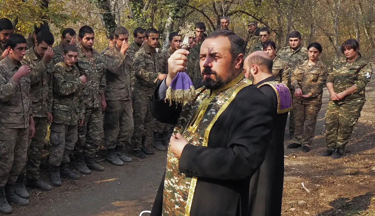 Pendeta Aristakes Hovhannisyan (kanan) dan Sebeos Galachyan melakukan upacara pembaptisan untuk tentara etnis Armenia di sebuah kamp militer dekat garis depan konflik di wilayah separatis Nagorno-Karabakh, Azerbaijan, Senin (2/11/2020). (AP Photo)