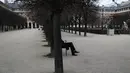 Seorang pria duduk di taman Royal Palais di Paris (22/3/2021).Sementara pemerintah Prancis bersikeras bahwa aturan tersebut tidak akan seketat di masa lalu, tindakan tersebut dikritik karena dianggap berantakan. (AP Photo/Lewis Joly)