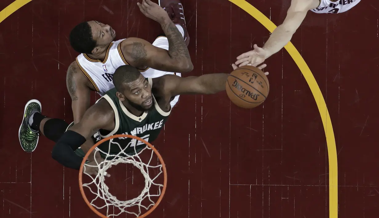 Pemain Milwaukee Bucks, Greg Monroe #15 berusaha melewati hadangan pemain Cleveland Cavaliers, Channing Frye (kiri)  dan Mike Dunleavy (tangan) pada laga NBA di Quicken Loans Arena, Cleveland, (21/12/2016). Cavaliers menang 113-102. (AP/Tony Dejak)