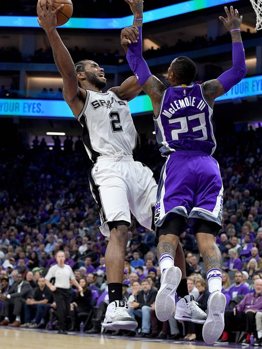 Aksi pemain San Antonio Spurs, Kawhi Leonard #2 melakukan tembakan saat dihadang pemain Sacramento Kings, Ben McLemore #23 pada ajang NBA di Golden 1 Center, Sacramento, California, Kamis (27/10/2016). (AFP/Thearon W. Henderson/Getty Images)