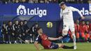 <p>Gelandang Real Madrid, Federico Valverde berusaha melewati pemain Osasuna, David Garcia selama pertandingan sepak bola La Liga Spanyol antara Osasuna dan Real Madrid di stadion El Sadar di Pamplona, Spanyol, Sabtu, 18 Februari 2023. (AP Photo/Alvaro Barrientos)</p>