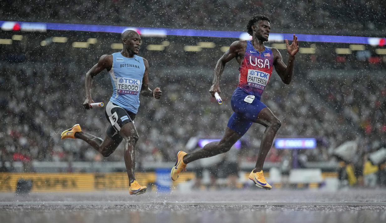 Pelari Amerika Serikat, Jacory Patterson (kanan) dan pelari Botswana, Letsile Tebogo (kiri) berkompetisi dalam nomor estafet 4 x 400 meter putra di Kejuaraan Dunia Atletik di Tokyo, Jepang, Minggu (21/09/2025). (AP Photo/Louise Delmotte)