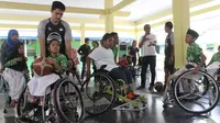 Timnas basket kursi roda Indonesia bersama anak-anak berkebutuhan khusus di Yayasan Pembinaan Anak Cacat (YPAC) Surakarta, Rabu (19/9/2018). (Bola.com/Ronald Seger)