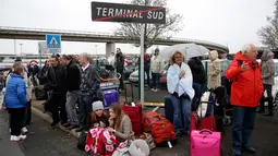 Pengunjung bandara berkumpul di sebuah titik saat usai dievakuasi petugas, Bandara Orly, Prancis, Sabtu (18/3). Evakuasi dilakukan karena terjadi insiden penembakan di Terminal Selatan sekitar pukul 08.30 waktu setempat. (AP Photo)