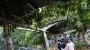 Warga melintasi jalur khusus pejalan kaki di kawasan Kampung Rambutan, Jakarta, Selasa (19/2). Atap rusak yang juga tidak dilengkapi dengan lampu penerangan mengganggu kenyamanan pejalan kaki. (Liputan6.com/Immanuel Antonius)