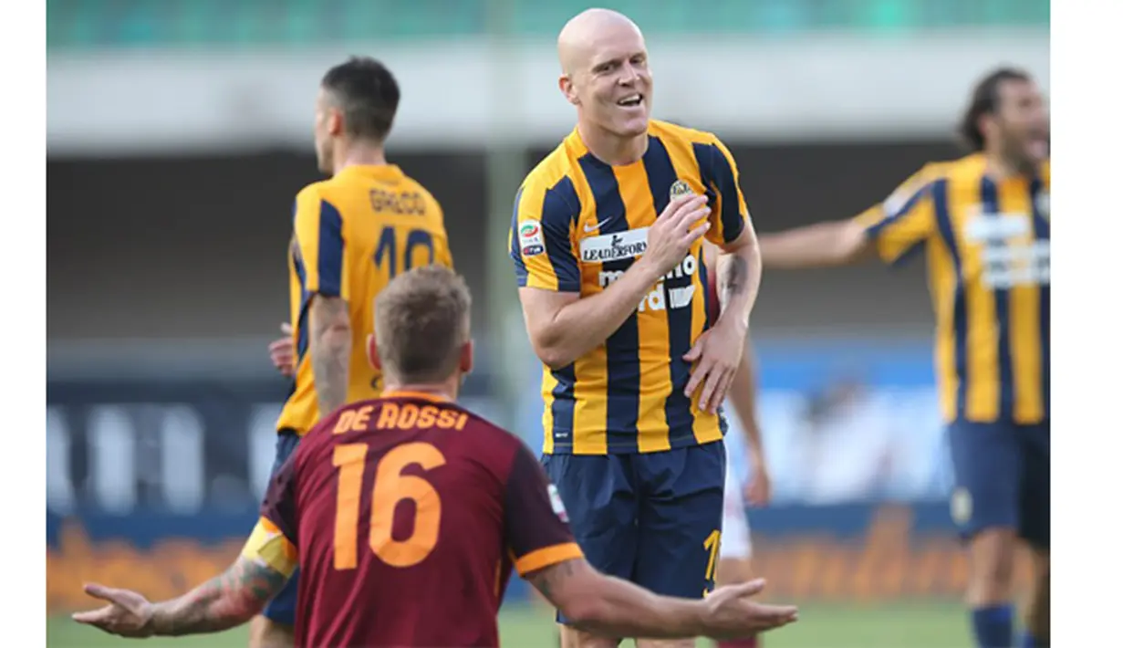  Pemain Roma, Daniele De Rossi berinteraksi dengan pemain Verona, Emil Hallfredsson pada laga Serie A di Stadion Marc'Antonio Bentegodi, Italia, Sabtu (22/8/2015). Roma gagal menang pada laga perdana musim ini. (AFP Photo/Alessandro Ruggeri)