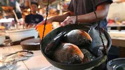 Pedagang menimbang ikan di Pasar Senen, Jakarta, (23/5). Kementerian Kelautan dan Perikanan (KKP) dengan Otoritas Jasa Keuangan (OJK) menargetkan penyaluran kredit untuk sektor kelautan dan perikanan pada tahun 2016. (Liputan6.com/Angga Yuniar)